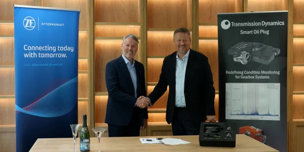 Transmission Dynamics and ZF Group leaders shaking hands behind a table