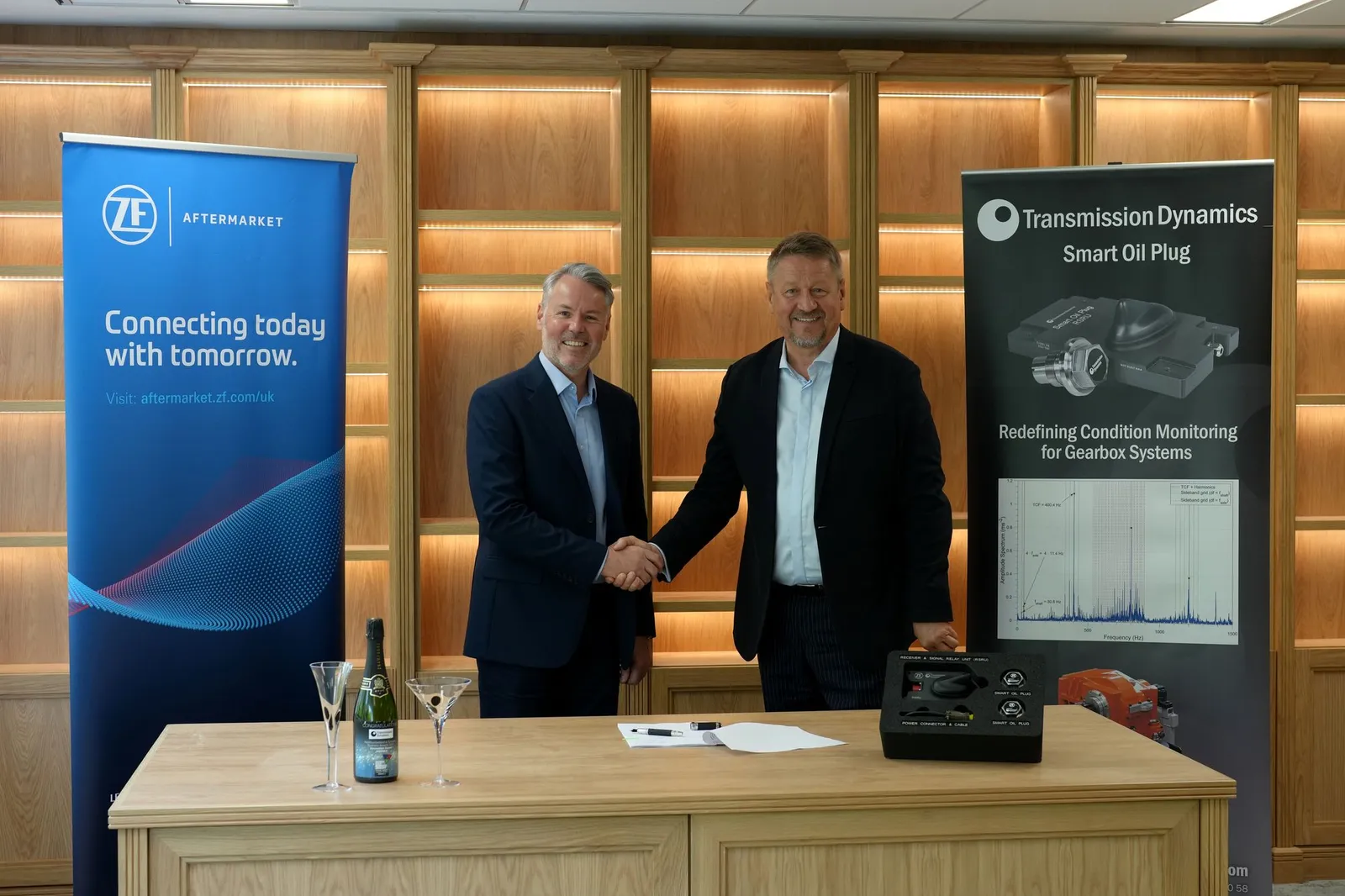 Transmission Dynamics and ZF Group leaders shaking hands behind a table